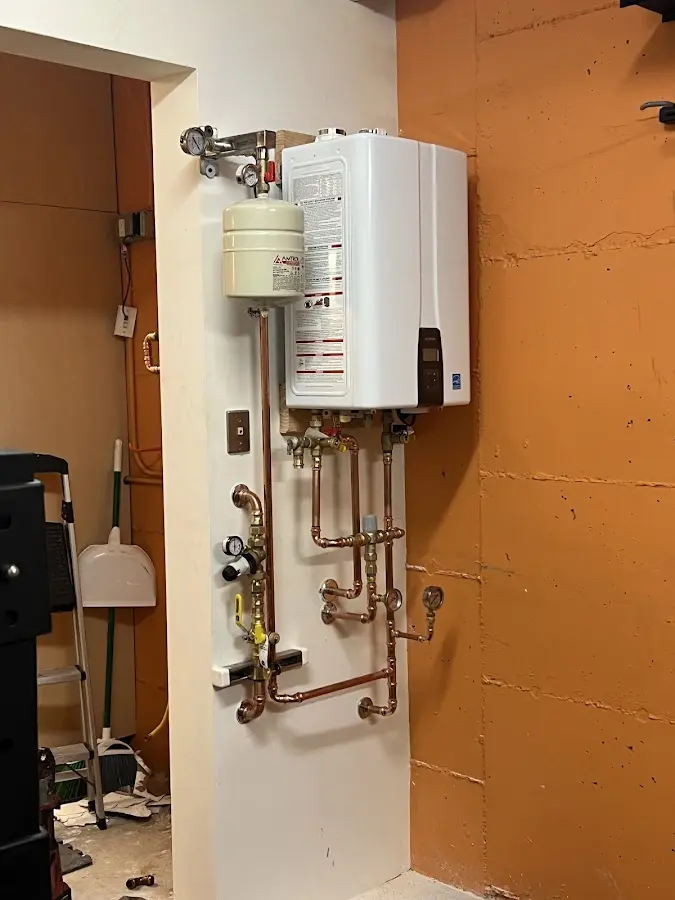 Plumbing technician inspecting water heater connections in Oakdale